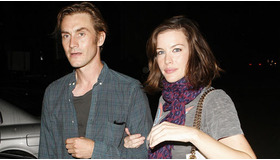 パパラッチを前にしても腕を組んで平然と歩くリヴとロイストン。  -(C) Splash/AFLO