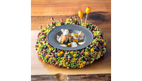 色鮮やかな季節のリースで提供される「ウズラのロースト 黒トリュフ かぼちゃ ブリオッシュ サフラン風味のジュレ フォアグラとアップルのロリポップ」。