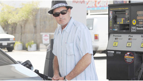 愛車のメルセデスにガソリンを入れるチャーリー・シーン　-(C) AFLO
