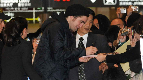 成田空港に到着早々、サインを求めるファンの声に応えるロバート