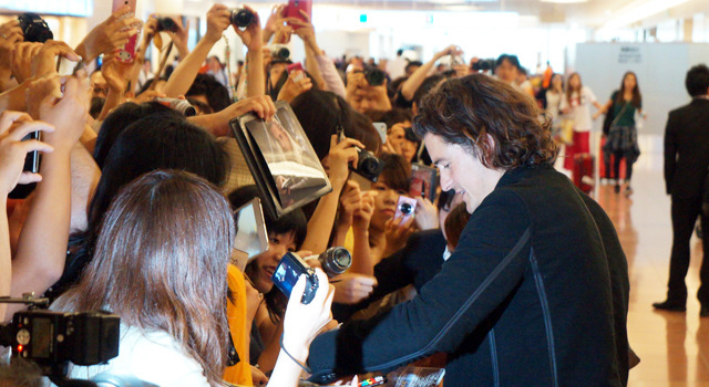 羽田空港でファンサービスを行う、オーランド・ブルーム／主演作『ケープタウン』で緊急来日
