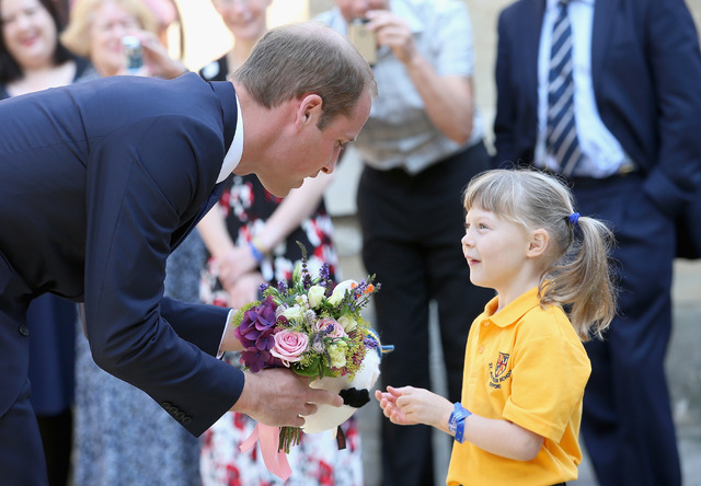 2歳になるイザベラ・ローリングスちゃんから花束を受け取る英ウィリアム王子