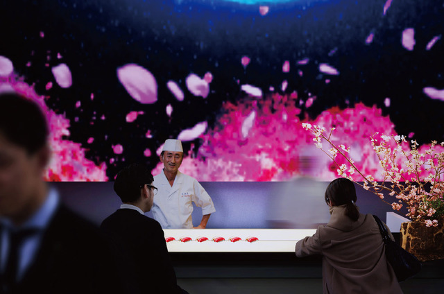 新・美食倶楽部：桜の木のオブジェと春をイメージしたプロジェクションの演出の下、「銀座 久兵衛」、「紀尾井町 福田家」の「美食の一品」が提供される。