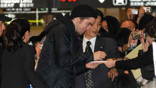 成田空港に到着早々、サインを求めるファンの声に応えるロバート