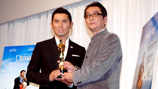 オスカー像を手に笑顔を見せる本木雅弘と滝田洋二郎監督