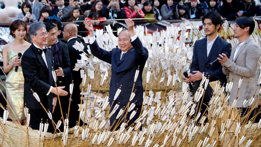 黄金の矢を手に掲げるジョン・ウー監督