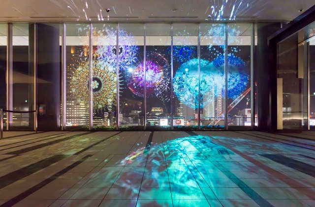 万華鏡花火が一面を覆い尽くし、はじけると元の夜景に戻っている。はじけた花火の破片がキラキラと輝いていて幻想的な美しさを奏でる。