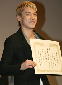 卒業証書を手に笑顔を見せる小栗さん