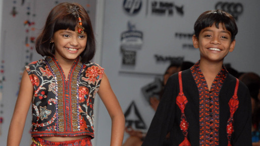 共演のアズルディン・モハメド・イスマイルと一緒にファッションショーを歩くルビーナ -(C) Rex Features / AFLO