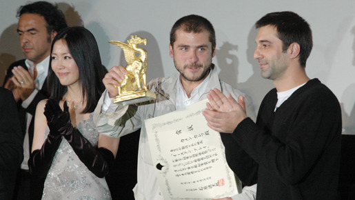 トロフィーを掲げるカメン・カレフ監督。隣には映画祭大使の木村佳乃
