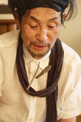 サヌカイトを口にくわえる吉増剛造 2015 年 Photo: Kioku Keizo