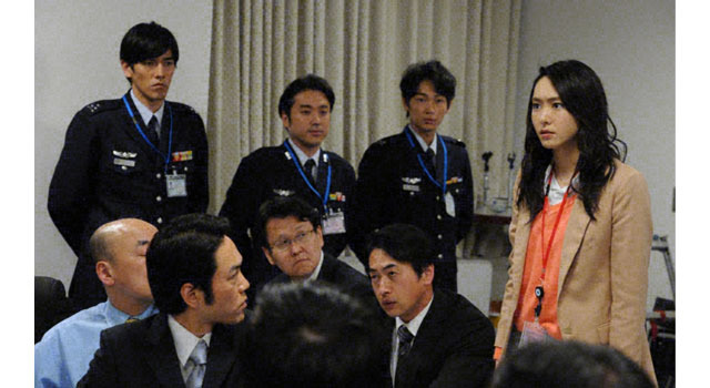 「空飛ぶ広報室」第2話（4月21日放送）：防衛省の緊急記者会見に入ったリカ（新垣結衣・右）は、元報道記者だけあって、空幕長を問い詰めるが…。（後列左から：要潤、ムロツヨシ、綾野剛）-(c) TBS