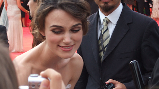 レッド・カーペットでにこやかにサインに応じるキーラ